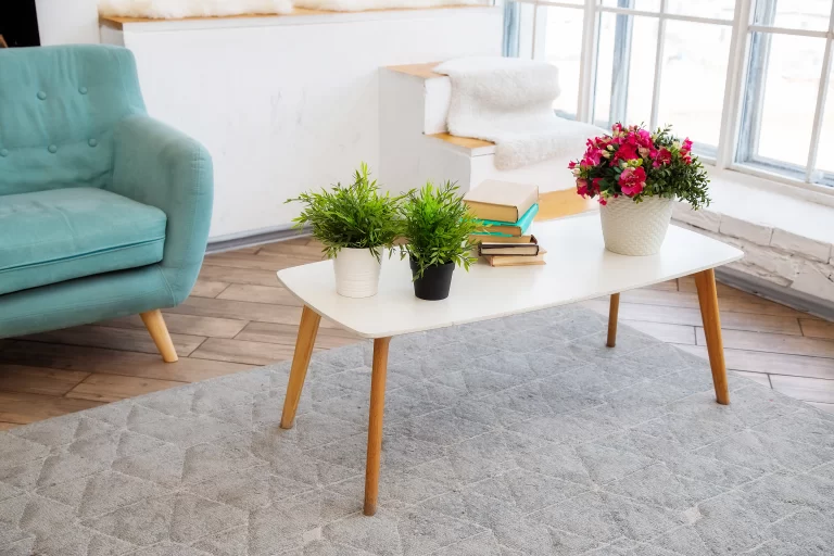 white-coffee-table-stands-near-window-with-potted-plants-books-it-bright-living-room